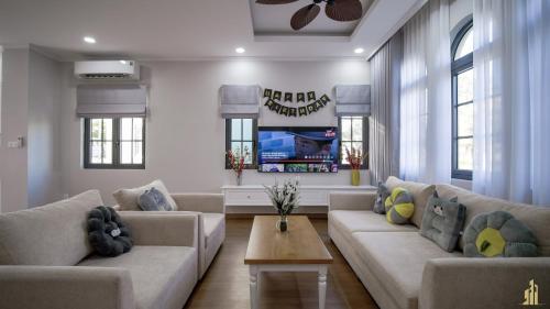 a living room with two couches and a tv at JB. Nguyễn Villa NovaWorld Phan Thiết in Phan Thiet