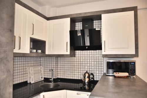 uma cozinha com armários brancos, um lavatório e um micro-ondas em STELLA APART-SUIT HOTEL -All Inclusive- em Antalya