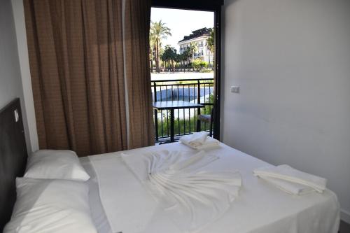 a white bed with a view of a balcony at STELLA APART-SUIT HOTEL -All Inclusive- in Antalya