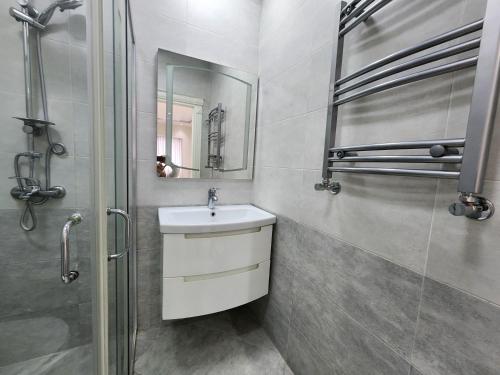 a bathroom with a sink and a mirror and a shower at Park Azure Best apartment in Baku