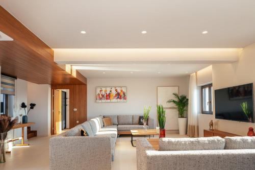 a living room with couches and a tv at Vellis Residence in Stavromenos