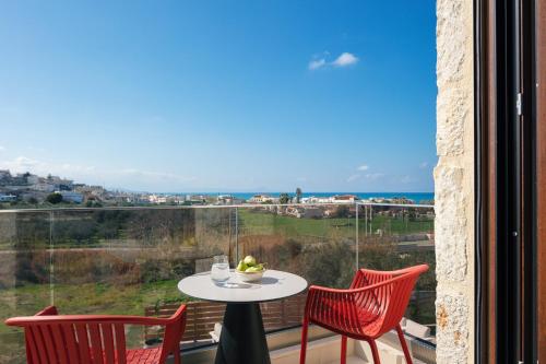a table and chairs on a balcony with a view of the ocean at Vellis Residence in Stavromenos