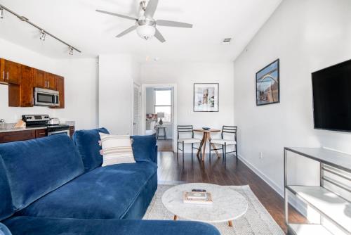 a living room with a blue couch and a tv at CozySuites Music Row Bold 1BR w free parking in Nashville