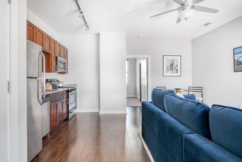 a living room with blue couches and a kitchen at CozySuites Music Row Bold 1BR w free parking in Nashville