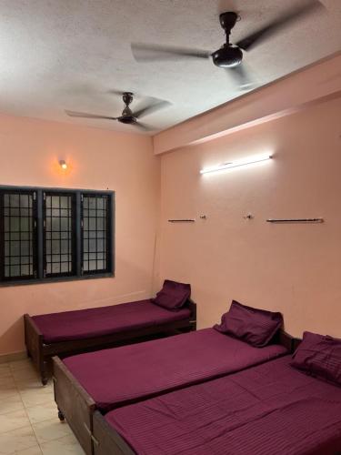 a room with two beds and a ceiling at M K Raja Hotel in Kelambākkam