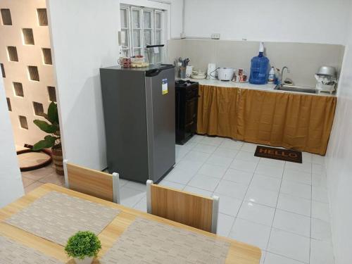 uma cozinha com uma mesa e um frigorífico num quarto em SOFI Homestay Butuan em Butuan