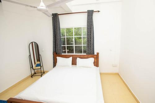 a bedroom with a bed and a window at Ama Residency & Homestay Kandy in Hindagala