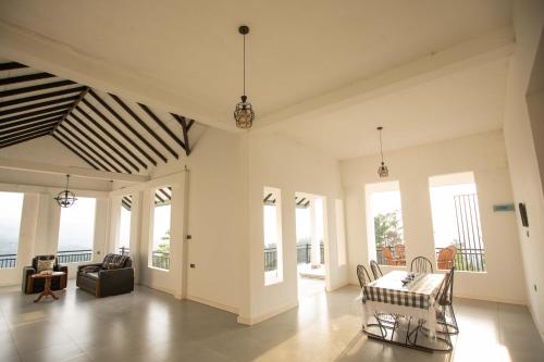 sala de estar con mesa, sillas y ventanas en Ama Residency & Homestay Kandy, en Hindagala