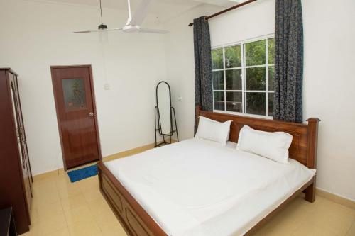 1 dormitorio con cama y ventana en Ama Residency & Homestay Kandy, en Hindagala