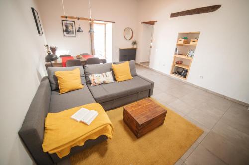 a living room with a gray couch with yellow pillows at Casa del Mercado in Haría
