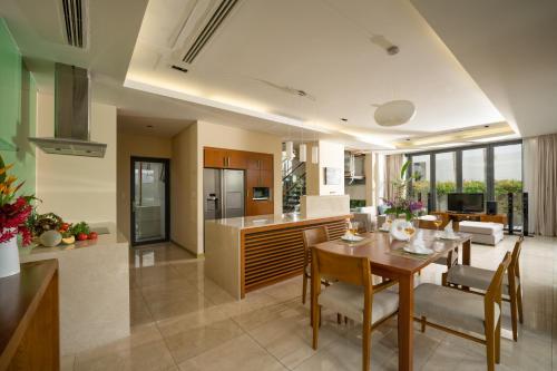 uma cozinha e sala de estar com mesa e cadeiras em Blue Sky & Villas Beach Resort em Da Nang