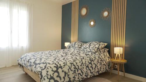 une chambre avec un lit et deux miroirs au mur dans l'établissement Au calme - Maison avec grand jardin - Proche zoo de Beauval, à Vicq-sur-Nahon