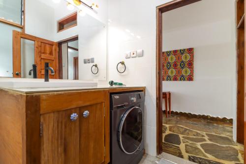 a bathroom with a sink and a washing machine at Mayweather One Bedroom Apartment, with Beach Access, Malindi in Malindi