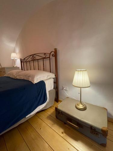 カターニアにあるGli appartamenti di Agataのベッドルーム1室(ベッド1台、スーツケースのランプ付)