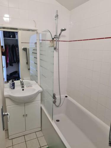 une salle de bain blanche avec un lavabo et une douche dans l'établissement Studio avec piscine à 300m de la mer, à Les Sables Vignier