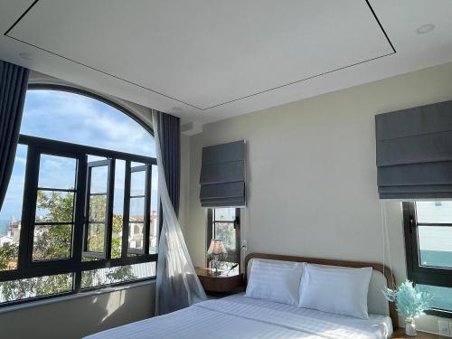 a bedroom with a bed and a large window at JB. Nguyễn Villa NovaWorld Phan Thiết in Phan Thiet