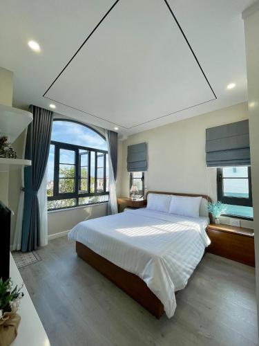 a bedroom with a large bed and a large window at JB. Nguyễn Villa NovaWorld Phan Thiết in Phan Thiet