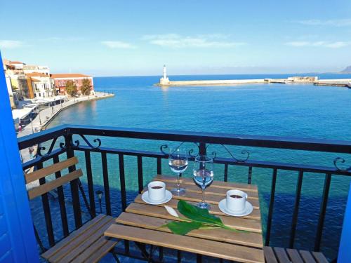 Una mesa en un balcón con vista al mar. en Lucia Hotel, en La Canea