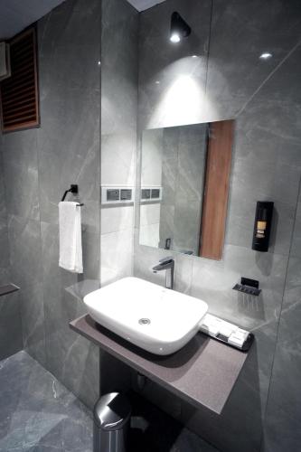 a bathroom with a white sink and a mirror at Dream Inn By Spring Tree in Surendranagar