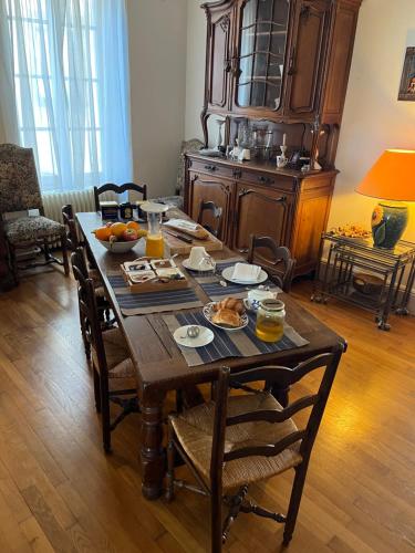 a wooden table with food on it in a living room at Logis Saint Vivant in Volnay