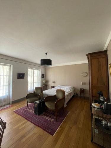 a bedroom with a bed and two chairs at Logis Saint Vivant in Volnay
