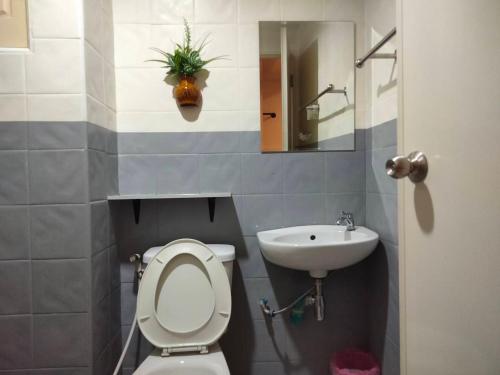 a bathroom with a toilet and a sink at Pilatus Apartment in Loei