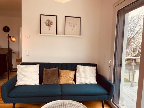 un sofá azul con almohadas en la sala de estar en Gemütliches Wohnen, en Worms
