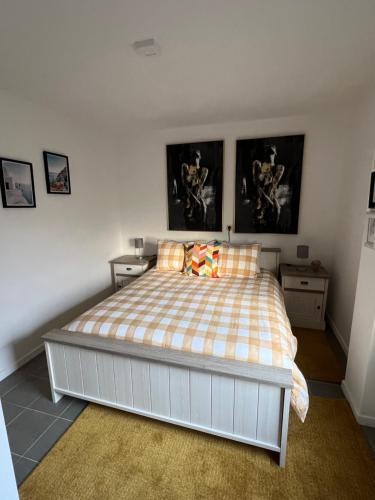um quarto com uma cama com duas mesas de cabeceira e duas fotografias em Résidence du moulin 2-B-1 em Boussu