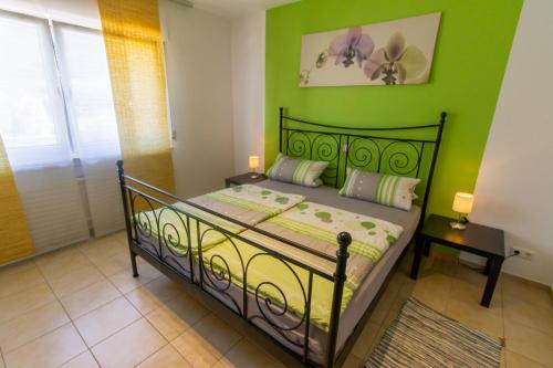 - une chambre dotée d'un lit avec un mur vert dans l'établissement Weingut Roth, à Kindel