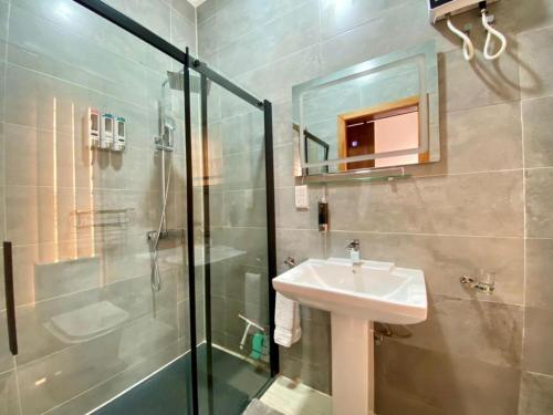 a bathroom with a sink and a shower at Inviting 3-Bed House in Awoshie Accra in Kwashieman