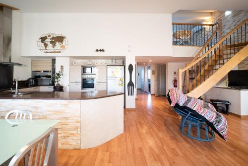 une cuisine et un salon avec un escalier dans une maison dans l'établissement Mialie Duplex familial classé 3 étoiles, au Boulou