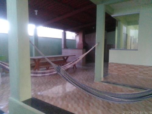 a hammock in the middle of a room with a table at Casa praia de Guriri temporada in Guriri
