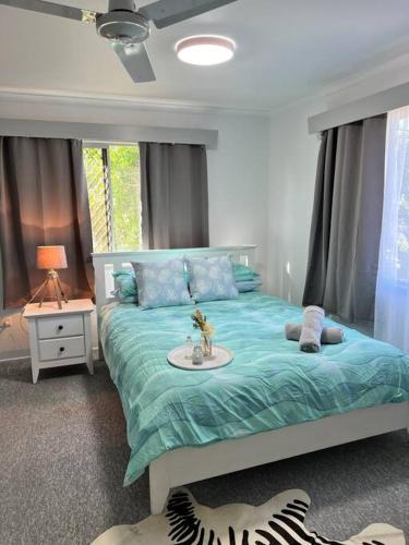 a bedroom with a bed with a blue comforter at Kirwan RetreatTownsville in Ross River