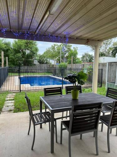 a black table and chairs with a pool at Kirwan RetreatTownsville in Ross River