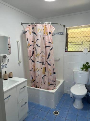 a bathroom with a toilet and a shower curtain at Kirwan RetreatTownsville in Ross River