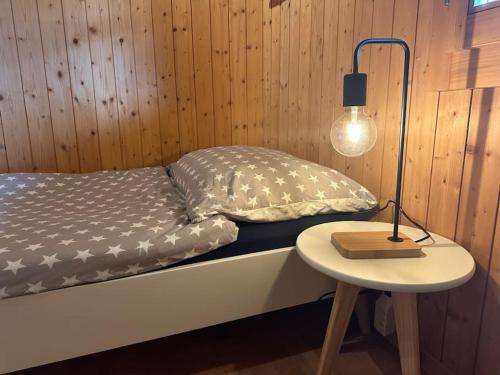 a bed in a room with a lamp and a table at Ferienwohnung im Chalet Bergruh - Hasliberg Reuti in Hasliberg
