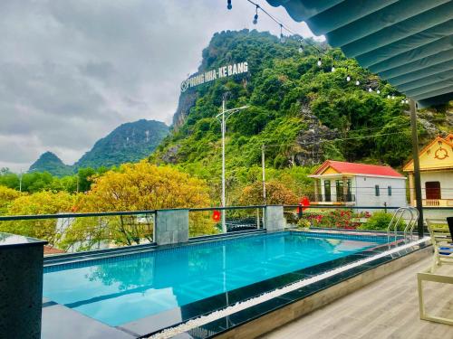 a swimming pool with a mountain in the background at Phong Nha - Tien's Cozy Homestay in Phong Nha