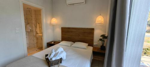 a bedroom with a white bed and a window at TOPAZ two in Siviri