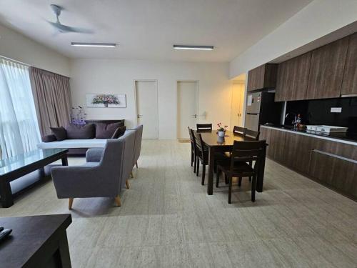 Una sala de estar con un sofá, una mesa y sillas. en Batu Ferringhi By The Sea 2BR Suite 6 Pax, en Batu Ferringhi