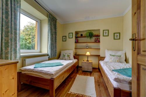 two beds in a room with a window at Apartmany Na Skle Malovane in Liptovská Kokava