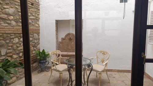 d'une terrasse avec une table et des chaises en verre. dans l'établissement Suite Comares, à Grenade