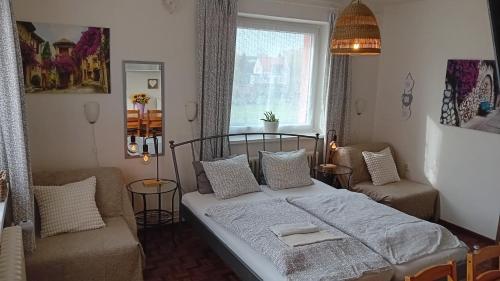 a bedroom with a bed and a chair and a window at Penzión Vilka Podhájčanka in Podhájska
