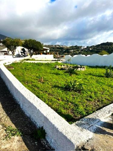 a field of green grass next to a road at Villa la Milanina in Lipari