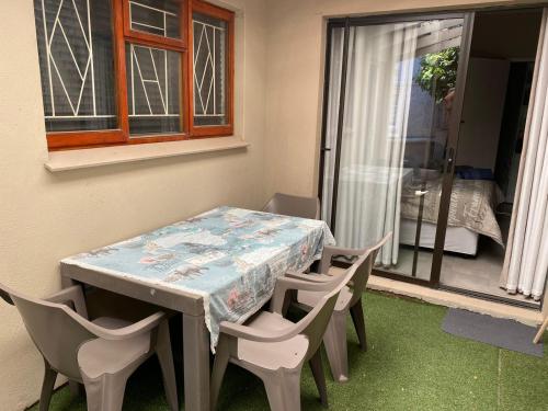 mesa y sillas en una habitación con ventana en Avo Tree Guesthouse en Paarl