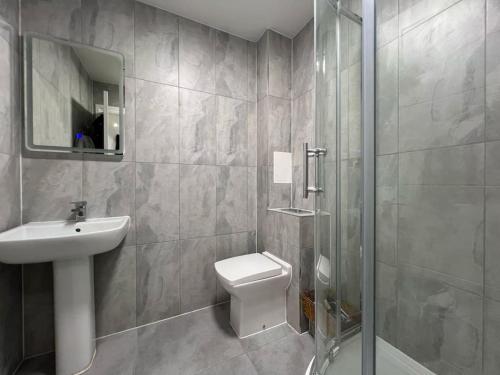 een badkamer met een toilet, een wastafel en een douche bij Monthly Discounts - Contractors - Business in Brentwood