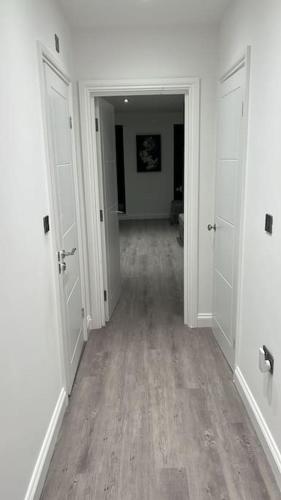 an empty hallway with white walls and wood floors at Monthly Discounts - Contractors - Business in Brentwood
