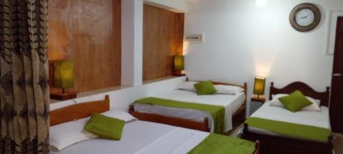 キャンディにあるThe Kandy Natureのホテルルーム ベッド2台&緑のシーツ付