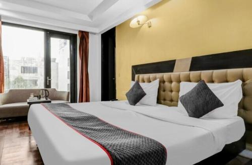 een hotelkamer met een groot bed en een bank bij Cordial Home in New Delhi