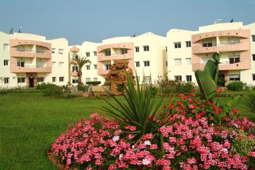 a view of a building with flowers in a yard at Mohammedia Plage et piscines in Mohammedia