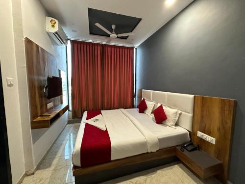 - une chambre avec un lit et un rideau rouge dans l'établissement Hotel Dumas Near Airport, à Surate